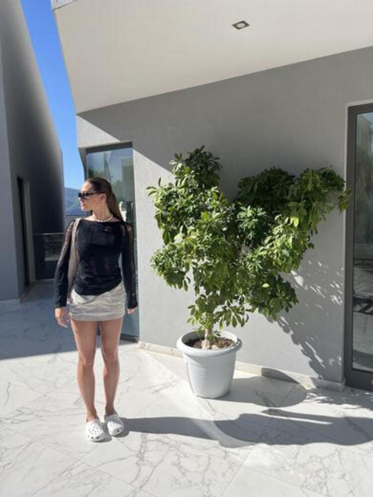 Cool neutral coloured outfit with beige cargo skirt, white crocs and black sunglasses Cool neutral coloured outfit with beige cargo skirt, white crocs and black sunglasses