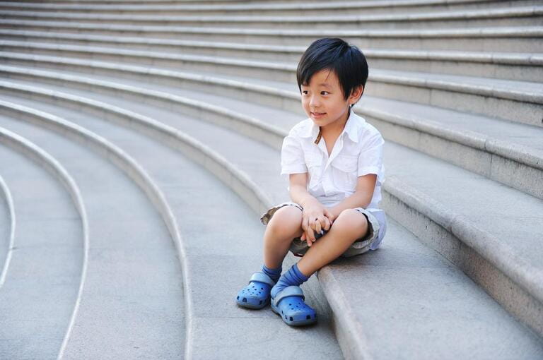 Cute schoolboy sitting on the stairs