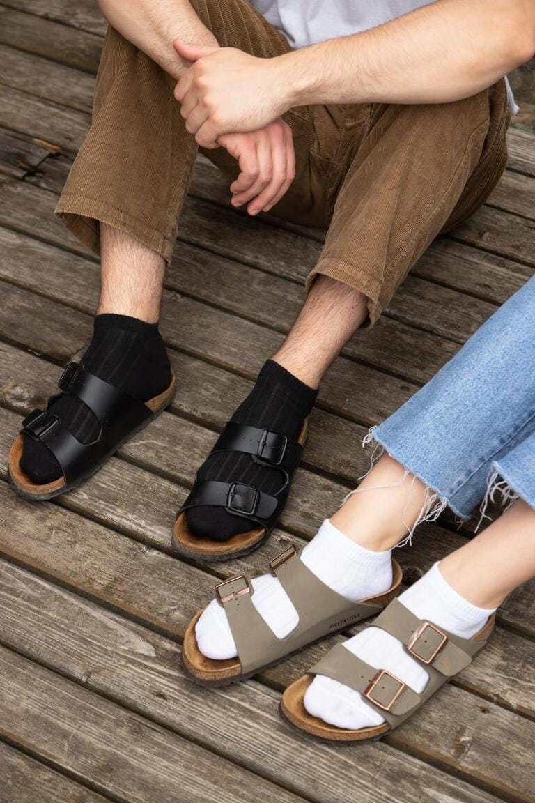 Guy in black socks and girl in white socks on the old wooden floor Guy in black socks and girl in white socks on the old wooden floor