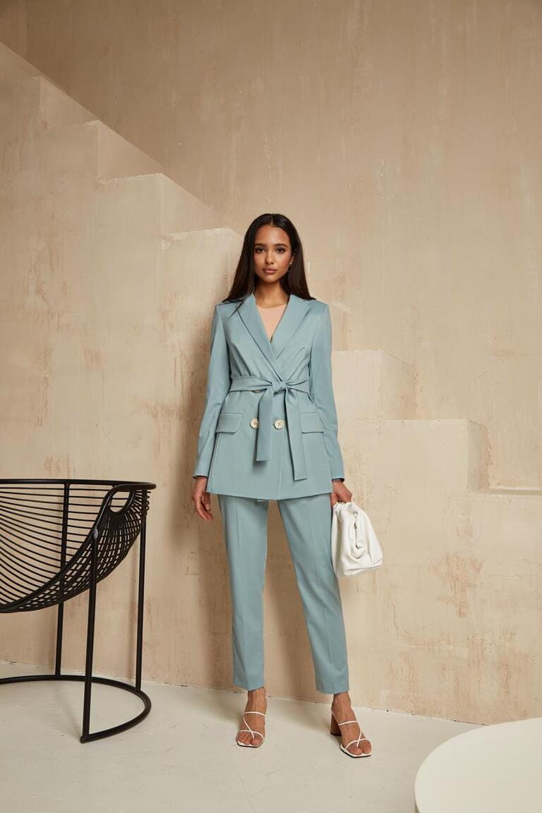 Beautiful brunette woman natural make up wear fashion clothes casual dress code office style blue jacket and pants suit for romantic date business meeting accessory bag interior boho stairs flowerpot.