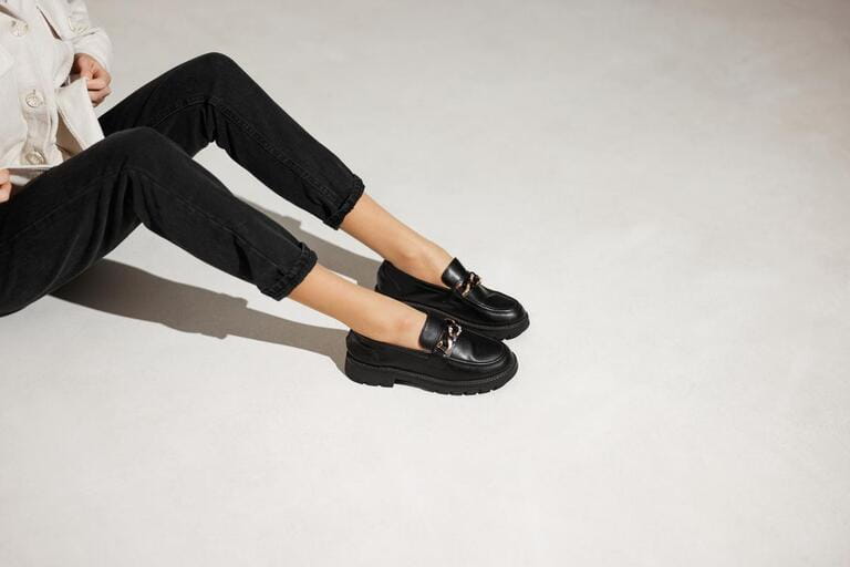 black loafers on female legs close-up black loafers on female legs close-up