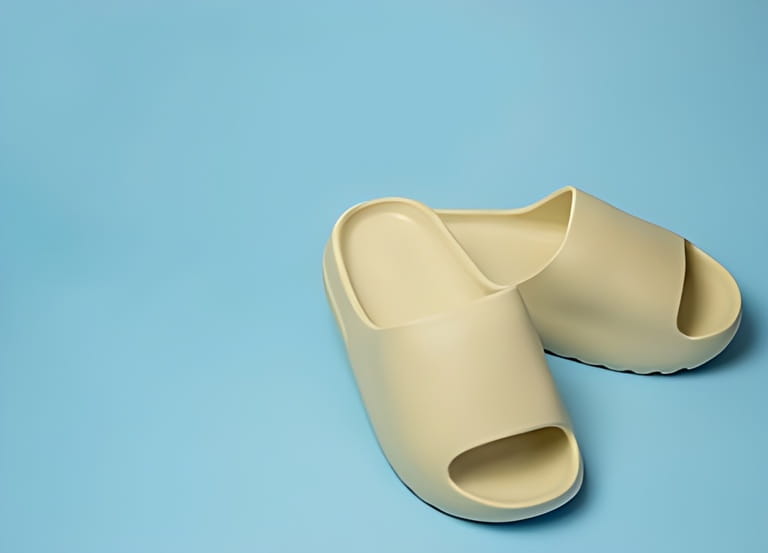 A pair of slides with an open toe pillow isolated on a colored background. Soft slippers A pair of slides with an open toe pillow isolated on a colored background. Soft slippers